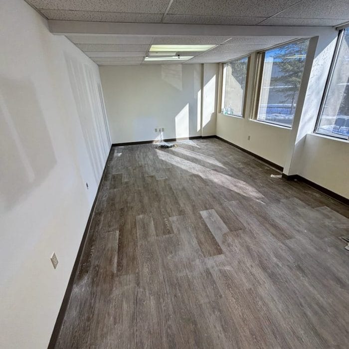 Cleaned commercial office space with hardwood flooring and natural light from windows, ready for occupancy after professional cleaning services.